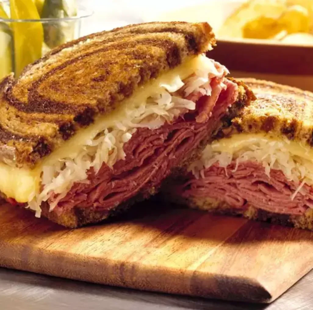 Two halves of a sandwich stuffed with meat and cheese.