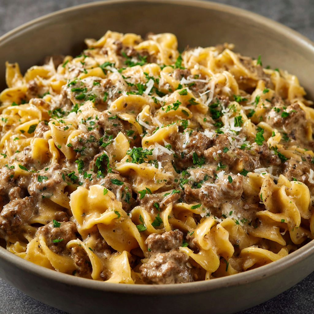 A bowl of pasta with meat and cheese.