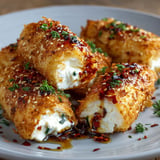 A plate of fried food with chili honey sauce.